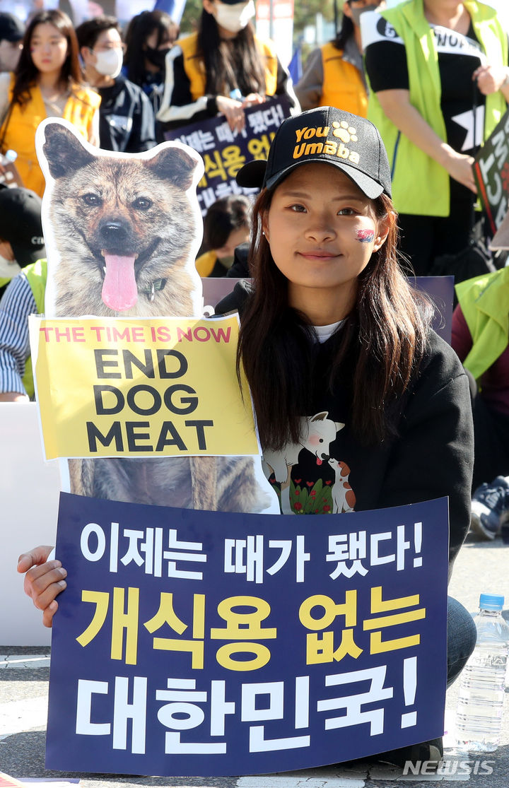 [서울=뉴시스] 조성봉 기자 = 29일 오후 서울 여의도 국회 앞에서 열린 '개 식용 금지법 제정 촉구' 집회에서 참가자가 피켓을 들고 있다. 동물권 대국민연대는 공동선언문을 통해 “정부와 국회는 완전한 개식용종식을 위한 입법과 실행에 지금 당장 나서라”고 촉구했다. 2023.10.29. suncho21@newsis.com