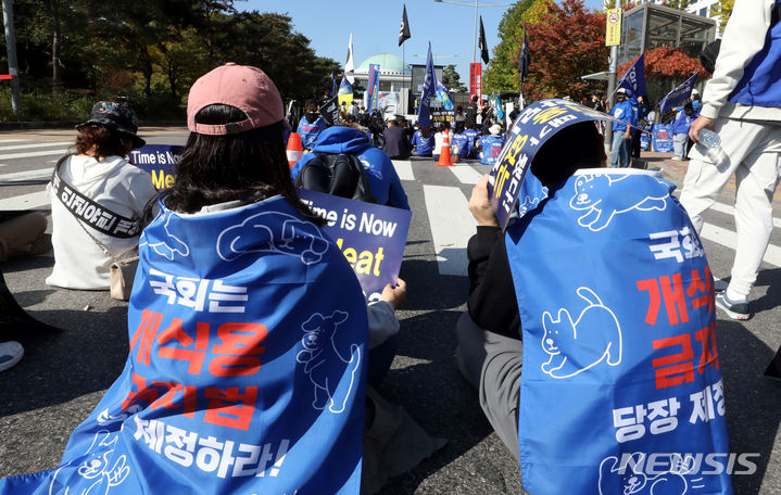 [서울=뉴시스] 조성봉 기자 = 29일 오후 서울 여의도 국회 앞에서 열린 '개 식용 금지법 제정 촉구' 집회에서 참가자들이 구호를 외치고 있다. 동물권 대국민연대는 공동선언문을 통해 “정부와 국회는 완전한 개식용종식을 위한 입법과 실행에 지금 당장 나서라”고 촉구했다. 2023.10.29. suncho21@newsis.com