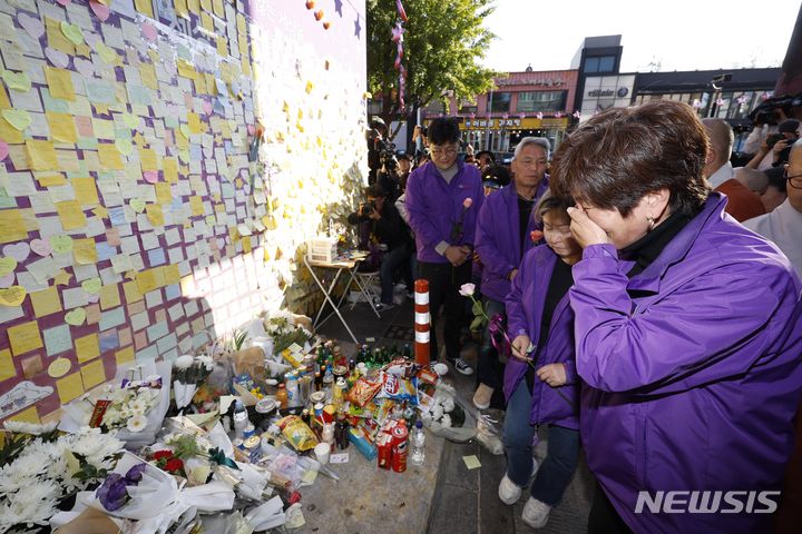 [서울=뉴시스] 김선웅 기자 = 10·29 이태원참사 1주기인 29일 서울 용산구 이태원 거리 '10.29 기억과 안전의 길'에서 참사 유가족들이 헌화를 하고 있다. (공동취재사진) 2023.10.29. photo@newsis.com