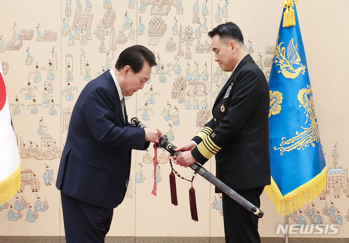 [서울=뉴시스] 전신 기자 = 윤석열 대통령이 30일 서울 용산 대통령실 청사에서 열린 장성 진급·보직 신고 및 삼정검 수치 수여식에서 대장으로 진급한 김명수 합동참모본부 의장 후보자의 삼정검에 수치를 직접 달아주고 있다. (대통령실통신사진기자단) 2023.10.30. photo1006@newsis.com