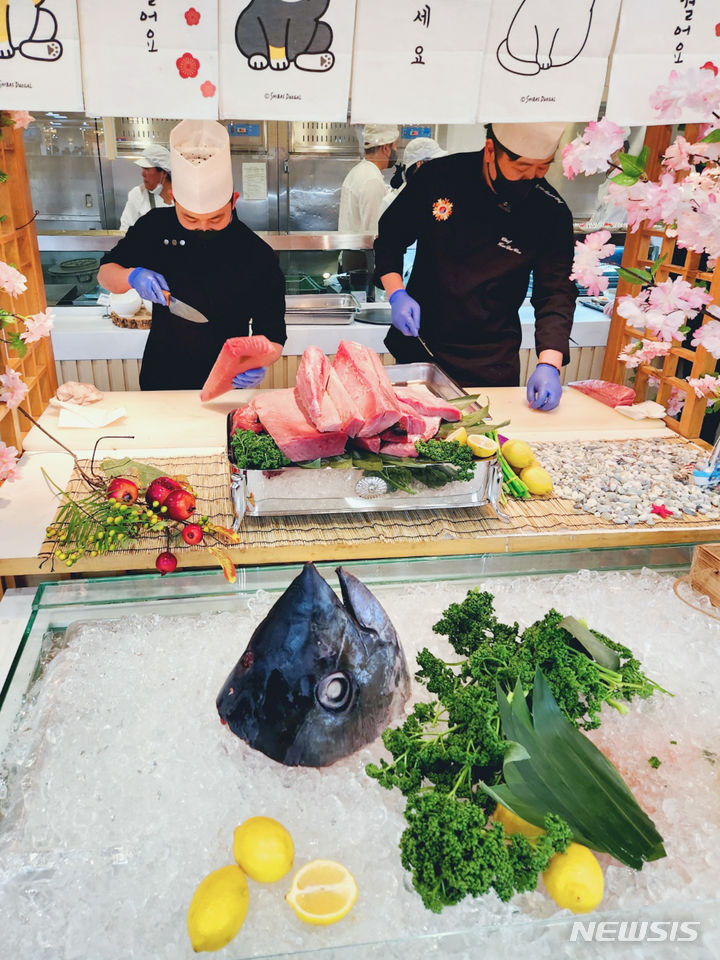 [서울=뉴시스] 현대그린푸드가 운영 중인 단체급식사업장에서 '즉석 참치해체쇼'가 진행되는 모습. (사진=현대백화점그룹 제공)