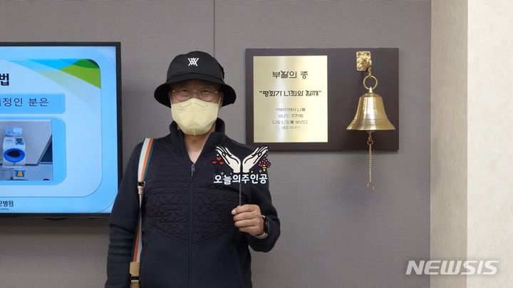 [서울=뉴시스]가톨릭대학교 서울성모병원 암병원은 항암 치료가 끝나는 것을 축하하고 새로운 시작을 응원하는 ‘부활의 종’을 이달 중 설치하고 암 환자가 항암치료 마지막 날 힘차게 종을 울리는 세레모니를 시작했다고 31일 밝혔다. 사진은 부활의종을 울린 1호 환자 원병희씨. (사진= 서울성모병원 제공) 2023.10.31. photo@newsis.com. 