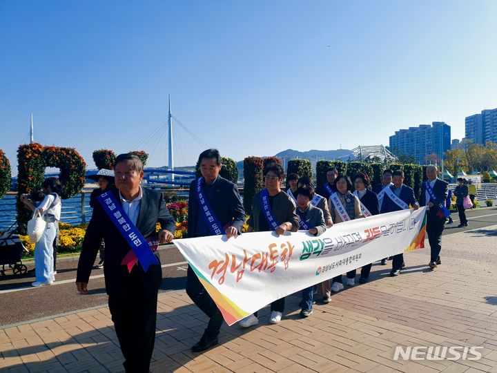 [창원=뉴시스]홍정명 기자=31일 오후 경상남도 사회대통합위원회 최충경(맨 앞) 위원장과 위원들이 창원시 마산합포구 마산국화축제 행사장을 누비면서 경남대통합 캠페인을 펼치고 있다.(사진=경남도 제공) 2023.10.31. photo@newsis.com