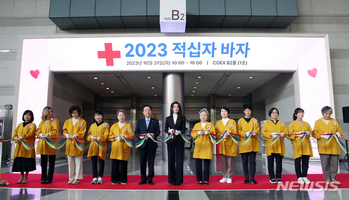 [서울=뉴시스] 전신 기자 = 윤석열 대통령 부인 김건희 여사가 31일 서울 강남구 코엑스에서 열린 2023 적십자 바자 행사에서 개시를 알리는 테이프 커팅을 하고 있다. 2023.10.31. photo1006@newsis.com