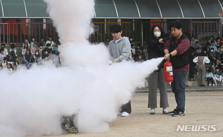 [수원=뉴시스] 김종택기자 = 31일 경기도 수원시 영화초등학교에서 열린 '2023 재난대응 안전한국훈련'에서 학교 관계자와 학생들이 화재 진화 훈련을 하고 있다. 2023.10.31. jtk@newsis.com