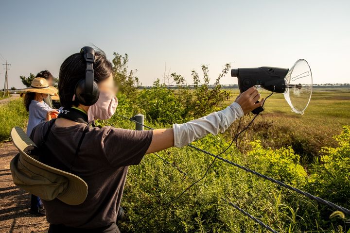 [수원=뉴시스] 작가 김양우의 '공기 흐름 소리'(Air Flow Sound)는 경기 수원시와 화성시 일대에서 공군비행장 이전과 관련해 비행기 소리와 인근의 떠다니고 흘러가는 소리를 탐구하고 채집하며 그 결과물을 소개한다. 사진은 '화성습지워크숍' 진행 모습으로 참가자들은 화성습지 일대의 철새 소리를 채집하고 철새를 관찰하며 공부했다. (사진=수원문화재단 제공) 2023.11.02. photo@newsis.com *재판매 및 DB 금지
