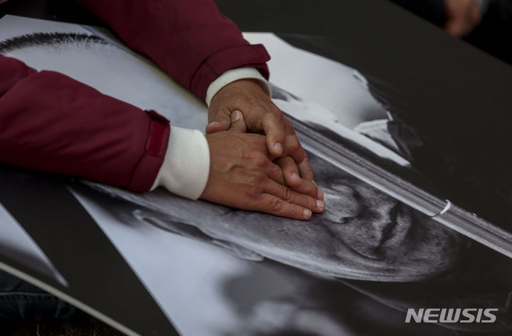 [서울=뉴시스] 정병혁 기자 = 2일 서울 중구 서울시청 인근에서 열린 방영환 열사 투쟁승리를 위한 공공운수노조 결의대회에서 한 조합원이 고 방영환 씨 사진을 만지고 있다. 2023.11.02. jhope@newsis.com