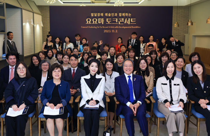 [서울=뉴시스] 윤석열 대통령 부인 김건희 여사가 2일 서울 용산구 대통령실 파인그라스에서 열린 ‘발달장애 예술인과 함께하는 요요마 토크콘서트’에서 첼리스트 요요마(Yo-Yo Ma), 발달장애 연주자, 학부모 등과 기념촬영 하고 있다. (사진=대통령실 제공) 2023.11.02. photo@newsis.com *재판매 및 DB 금지