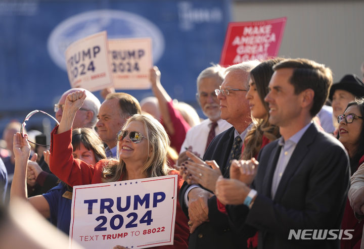 [휴스턴=AP/뉴시스] 도널드 트럼프 전 미국 대통령의 지지자들이 2일(현지시각) 텍사스주 휴스턴의 트렌드세터 엔지니어링 앞에서 "미국을 다시 위대하게"라고 적힌 손팻말을 들고 그의 연설을 듣고 있다. 2023.11.03.