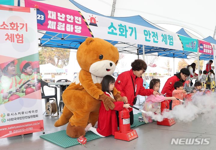 [충주=뉴시스] 이도근 기자= 2023 충주시 재난안전체험마당이 열린 3일 충북 충주시 탄금공원 안전체험 부스에서 어린이들이 충주시 마스코트 충주씨와 함께 소화기 체험을 하고 있다. (사진=충주시 제공) 2023.11.3. photo@newsis.com *재판매 및 DB 금지