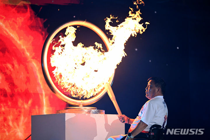 [목포=뉴시스] 이영주 기자 = 김종일(한전KDN) 론볼 감독이 3일 오후 전남 목포시 목포종합경기장에서 열린 제43회 전국장애인체전에서 성화를 점화하고 있다. 2023.11.03. leeyj2578@newsis.com