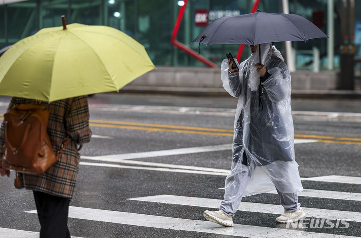 [서울=뉴시스] 정병혁 기자 = 비가 내린 지난 5일 서울 강남구 강남역 인근에서 한 시민이 우비를 입은 채 우산을 들고 이동하고 있다. 2023.11.05. jhope@newsis.com