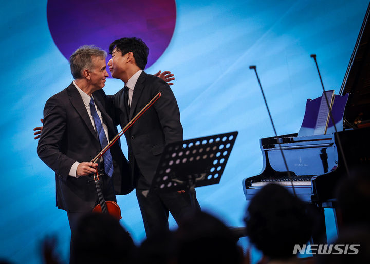 [서울=뉴시스] 김명년 기자 = 5일 오후 서울 종로구 청와대 춘추관에서 열린 '2023 블루하우스 콘서트'에서 미국인 바이올리니스트 길샤함과 한국인 피아니스트 신창용이 합주를 마치고 포옹하고 있다. 2023.11.05. kmn@newsis.com