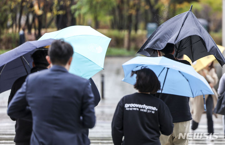 [서울=뉴시스] 정병혁 기자 = 서울지역에 강풍주의보가 내려진 6일 서울 영등포구 여의도환승센터에서 시민들이 우산을 부여잡은 채 이동하고 있다. 2023.11.06. jhope@newsis.com