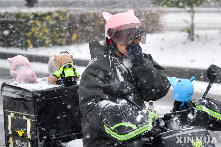 [창춘=신화/뉴시스] 6일 중국 지린성 창춘에서 한 배달원이 눈을 맞으며 이동하고 있다. 2023.11.07.