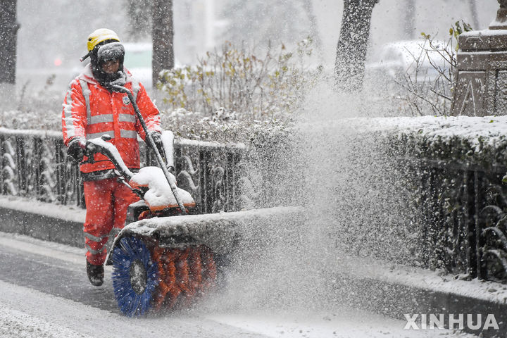 [창춘=신화/뉴시스] 눈이 내린 6일 중국 지린성 창춘에서 환경미화원이 제설작업을 하고 있다. 2023.11.07.