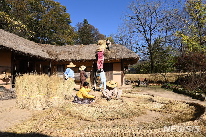 [용인=뉴시스] 김종택기자 = 절기상 입동(立冬)을 하루 앞둔 7일 경기도 용인 한국민속촌에서 관계자들이 초가지붕에 올릴 용마름과 이엉잇기 작업을 하며 겨울 준비를 하고 있다. 2023.11.07. jtk@newsis.com