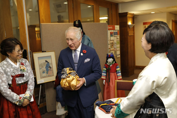 [런던=AP/뉴시스] 찰스 3세(가운데) 영국 국왕이 8일(현지시간) 런던의 뉴몰든 감리교회를 방문해 선물 받은 김치를 들고 있다. 2023.11.09.