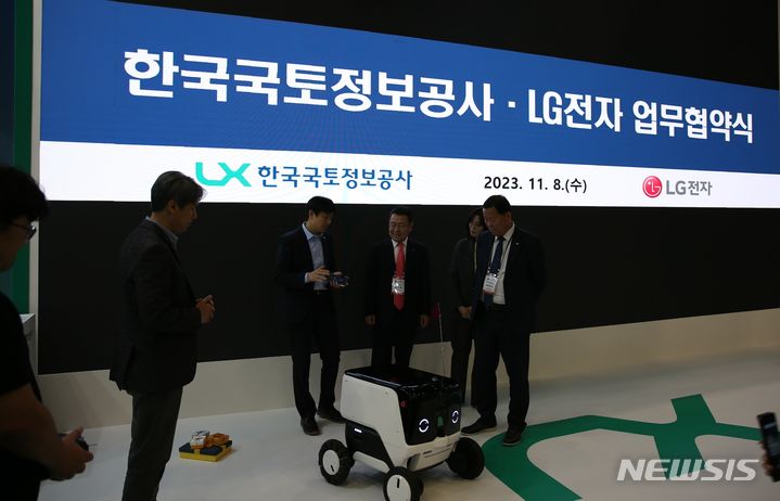 [서울=뉴시스]LX공사 최송욱 공간정보본부장, LG전자 백승민 로봇선행연구소장 등이 11월8일 일산 킨텍스에서 로봇 배송 기술 협력을 위한 시연을 참관하고 있다.(사진=LX공사 제공)