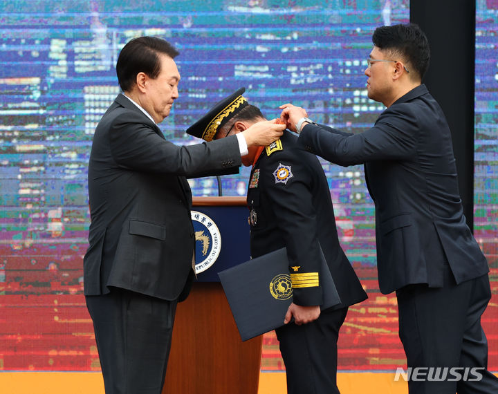 [서울=뉴시스] 전신 기자 = 윤석열 대통령이 9일 서울 용산어린이정원 잔디마당에서 열린 제61주년 소방의 날 기념식에서 엄준욱 인천소방본부 본부장에게 홍조근정훈장을 수여하고 있다. 2023.11.09. photo1006@newsis.com