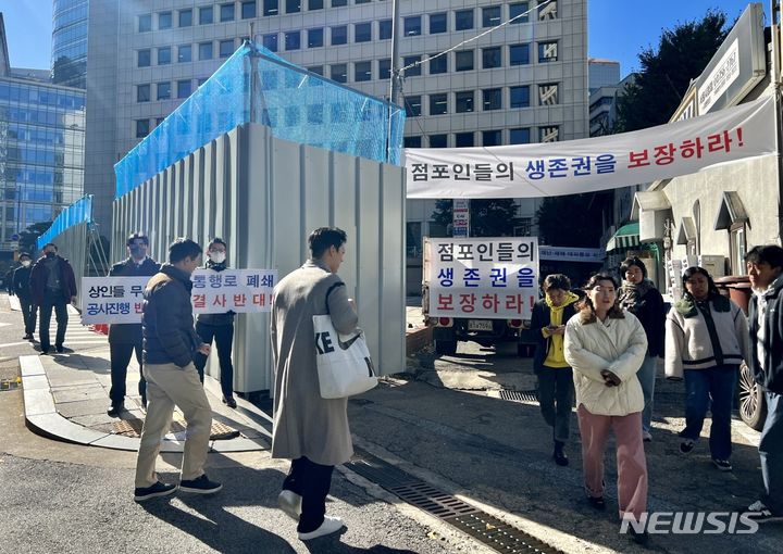 [서울=뉴시스]서울 중구 소공동 보행통로 폐쇄에 반발하는 상인들