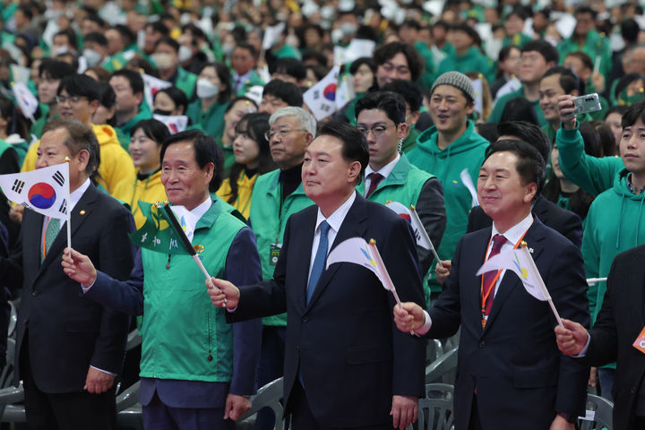 [고양=뉴시스] 윤석열 대통령이 12일 경기 고양시 킨텍스에서 열린 2023 전국새마을지도자대회에서 태극기를 흔들고 있다. 오른쪽부터 김기현 국민의힘 대표, 윤 대통령, 곽대훈 새마을운동중앙회장, 이상민 행정안전부 장관. (사진=대통령실 제공) 2023.11.12. photo@newsis.com *재판매 및 DB 금지