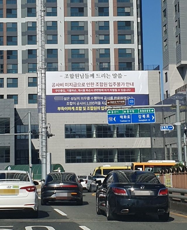 [울산=뉴시스] 울산 중구 A지역주택조합 신축 주상복합 건물 외벽에 걸린 '공사비 미지급으로 인한 조합원 입주불가 안내' 현수막. *재판매 및 DB 금지