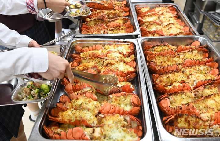 [수원=뉴시스] 김종택기자 = 14일 경기도 수원시 효원고등학교에서 학생들이 점심시간에 랍스터를 배식하고 있다. 탄소중립시범학교로 운영 중인 효원고는 학교 급식 음식물 쓰레기 줄이기 활동 결과 전년대비 처리비용 49.2% 절감, 쓰레기발생량 55% 감소에 적극 참여한 학생과 교직원들을 격려하기 위해 랍스터 테일 구이를 점심 식단으로 제공했다. 2023.11.14. jtk@newsis.com