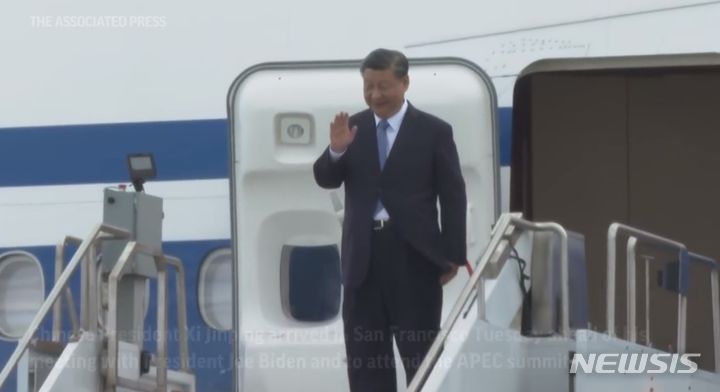 [서울=뉴시스] 시진핑 중국 국가주석이 미중 정상회담과 아시아태평양경제협력체(APEC) 정상회의를 위해 14일(현지시간) 샌프란시스코에 도착했다. 시 주석이 전용기에서 나와 손을 흔들어 인사하는 모습. 당시 시주석 부부가 무릅꿇고 수갑을 찬 모습의 조각을 만들었던 미국의 한 예술가를 괴롭히려 한 중국인 등 2명이 미국에서 기소됐다. <사진출처: AP 영상 캡쳐> 2025.6.10.