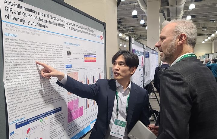 [서울=뉴시스] 한미약품 연구원(왼쪽)이 지난 2023년 11월 11일(현지 시간) 미국간학회 국제학술대회(AASLD)에서 연구를 설명하고 있다. (사진=한미약품 제공) 2023.11.15. photo@newsis.com *재판매 및 DB 금지