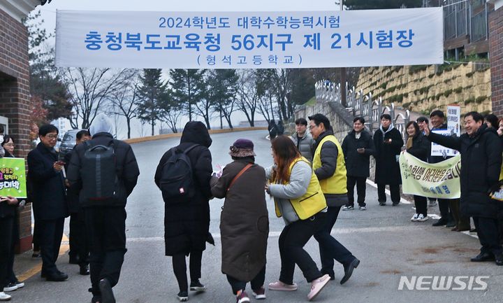 [증평=뉴시스] 강신욱 기자 = 2024학년도 대학수학능력시험일인 16일 충북교육청 56지구 21시험장이 마련된 증평 형석고등학교 교문에서 응원 단체 회원들이 수험생들에게 준비한 선물 꾸러미를 건네고 있다. 2023.11.16. ksw64@newsis.com