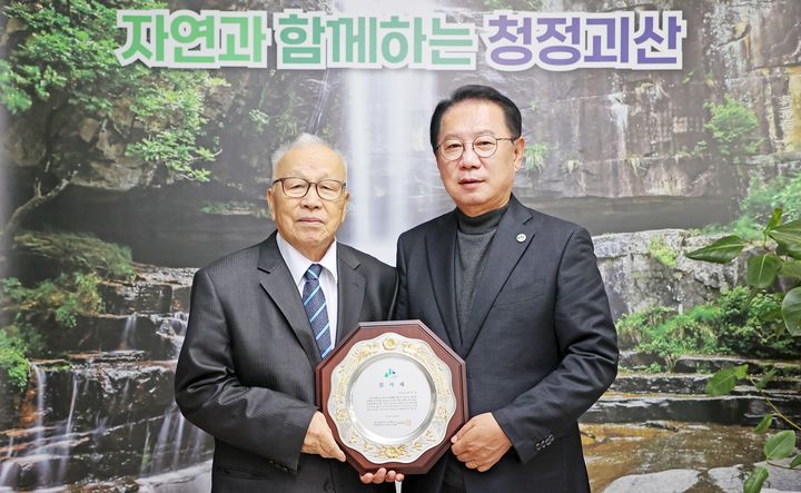 [괴산=뉴시스] 강신욱 기자 = 송인헌 충북 괴산군수가 16일 군청에서 대학찰옥수수 종자를 개발한 최봉호 박사로부터 대학찰옥수수를 괴산의 대표 농산물로 육성한 데 이바지한 공로로 감사패를 받고 있다. (사진=괴산군 제공) 2023.11.16. photo@newsis.com *재판매 및 DB 금지