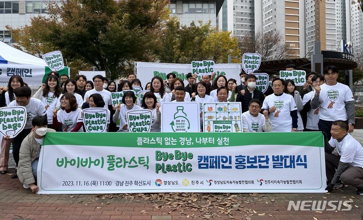 [진주=뉴시스]홍정명 기자=16일 경남 진주 혁신도시 인근에서 열린 '바이바이 플라스틱(Bye Bye Plastic) 캠페인 홍보단' 발대식 참석자들이 기념촬영하고 있다.(사진=경남도 제공) 2023.11.16. photo@newsis.com