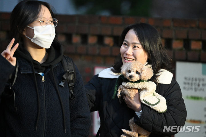 [광주=뉴시스] 이영주 기자 = 2024학년도 대학수학능력시험 당일인 16일 오전 광주 북구 경신여고(광주시교육청 26지구 제37시험장) 정문에서 한 어머니가 기르는 강아지와 함께 수험생 딸을 응원하며 인사하고 있다. 2023.11.16. leeyj2578@newsis.com