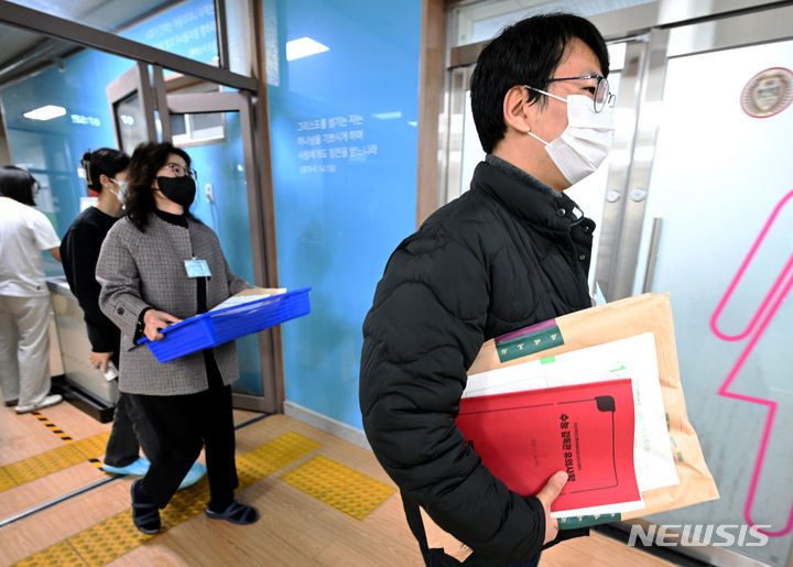 [광주=뉴시스] 이영주 기자 = 2024학년도 대학수학능력시험이 치러졌던 지난해 11월16일 오전 광주 북구 경신여고(광주시교육청 26지구 제37시험장)에서 시험 감독관이 시험지를 들고 교실로 이동하고 있다. 2023.11.16. leeyj2578@newsis.com