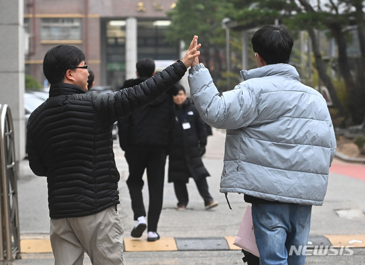 [수원=뉴시스] 김종택기자 = 2024학년도 대학수학능력시험일인 16일 오전 경기도 수원시 영통구 태장고등학교 앞에서 한 학부모가 수험생을 응원하고 있다. 2023.11.16. jtk@newsis.com