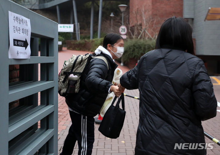 [서울=뉴시스] 김혜진 기자 = 2024학년도 대학수학능력시험일인 16일 오전 수능 시험장인 서울 중구 이화여자고등학교에서 한 학부모가 수험생 딸에게 도시락을 건네고 있다. 2023.11.16. jini@newsis.com