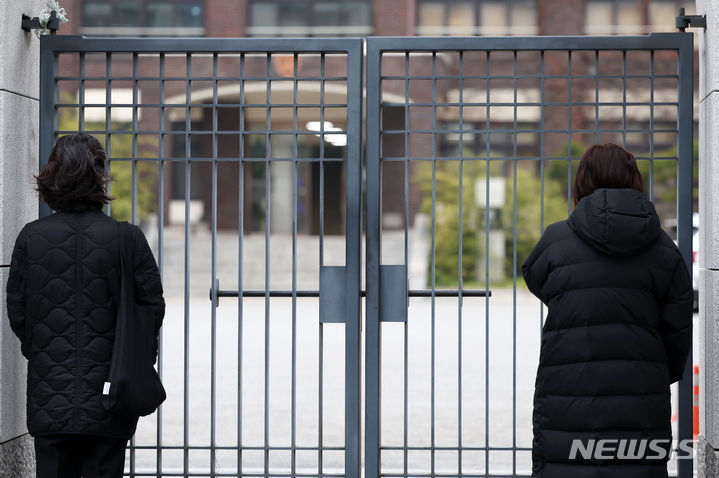 [서울=뉴시스] 홍효식 기자 = 2024학년도 대학수학능력시험날인 16일 서울 강남구 휘문고등학교 교문 앞에서 학부모들이 자녀들의 수능 선전을 기원하며 학교를 바라보고 있다. 2023.11.16. yesphoto@newsis.cm