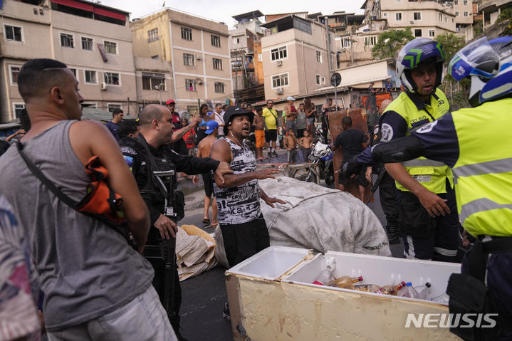 [리우데자네이루=AP/뉴시스] 지난 해 11월16일 브라질 리우데자네이루의 로치냐 빈민가에서 무더위 속 정전에 항의하는 주민들이 경찰과 언쟁을 하고 있다. 브라질 경찰은 2월 26일 빈민지역에 무장군을 투입해 대대적인 범죄자 단속을 벌였다. 2024. 02. 28.&nbsp; 