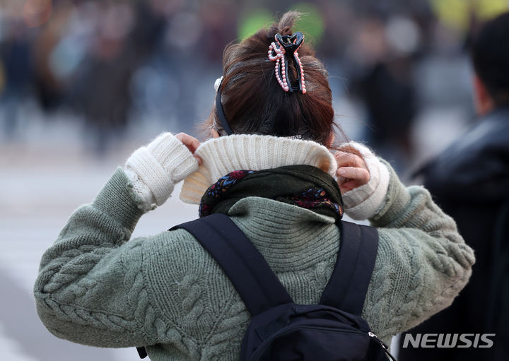 [서울=뉴시스] 김명년 기자 =지난 17일 오후 서울 종로구 세종대로 사거리에서 한 시민이 옷깃을 여미고 있다. 2023.11.17. kmn@newsis.com