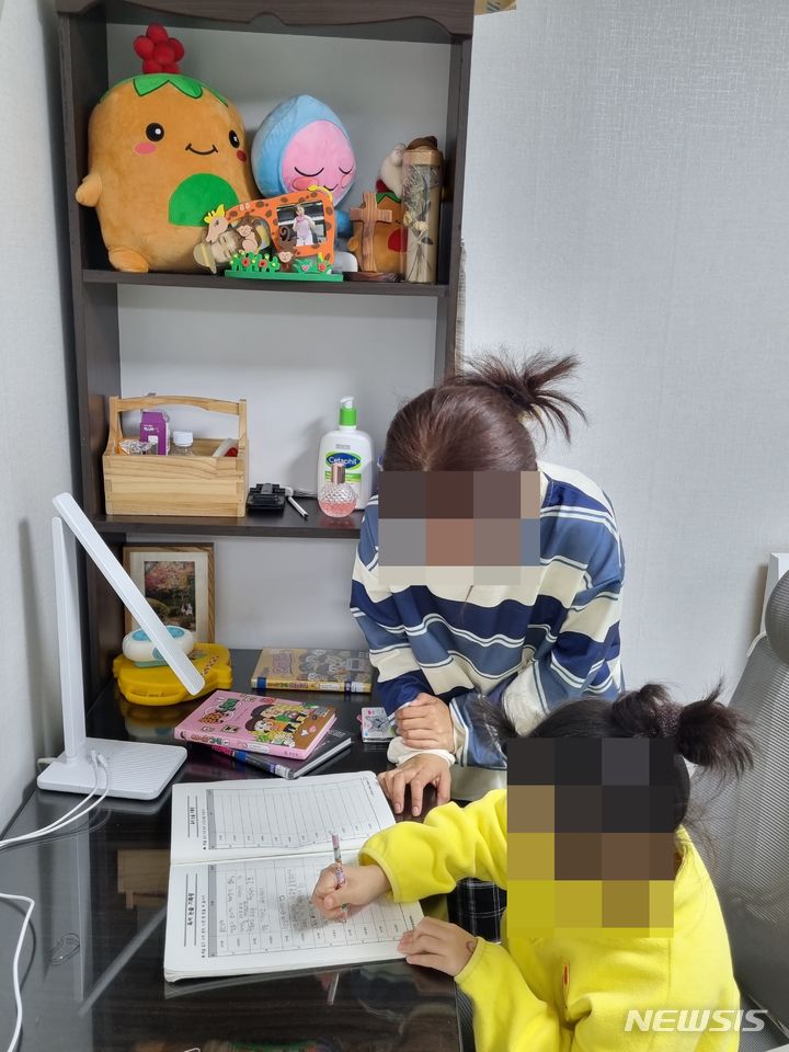 [서울=뉴시스]한국인 남편에게 수 년 간 폭력 피해를 당한 후 이혼한 캄보디아 이주여성 A씨가 딸의 공부를 봐주고 있다. A씨는 최근 폭력피해 이주여성 보호시설에서 퇴소한 후 딸과 함께 생활하고 있다. (사진=A씨 제공) 2023.11.25.