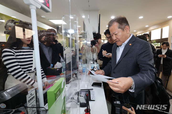 [서울=뉴시스] 권창회 기자 = 이상민 행정안전부 장관이 19일 서울 종로구 청운효자동 주민센터를 방문해 정부 행정전산망인 '새올'과 사회보장통합정보시스템 '행복이음'의 정상 작동 여부를 확인한 뒤 주민등록등본 서류를 발급받고 있다. (공동취재) 2023.11.19. photo@newsis.com