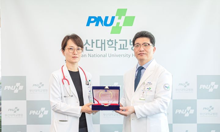 [부산=뉴시스] 정성운 부산대병원장(오른쪽)이 김영미 소아청소년과 교수에게 상패를 전달하고 있다. (사진=부산대병원 제공) *재판매 및 DB 금지