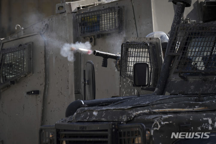 [서안지구=AP/뉴시스] 21일(현지시각) 요르단강 서안지구 발라타 난민촌에서 작전 중인 이스라엘 군인이 팔레스타인 주민들을 향해 최루탄을 쏘고 있다. 2023.11.22.