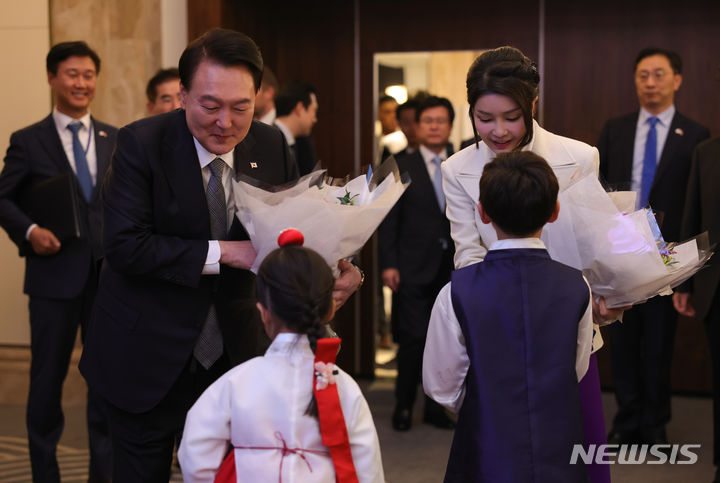 [런던=뉴시스] 전신 기자 = 영국을 국빈 방문한 윤석열 대통령과 부인 김건희 여사가 20일(현지시간) 런던 시내 한 호텔에서 열린 동포 초청 만찬 간담회에서 화동으로부터 꽃다발을 받고 있다. (공동취재) 2023.11.21. photo1006@newsis.com