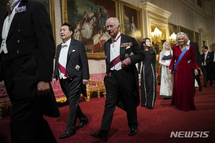 [런던=AP/뉴시스] 윤석열(왼쪽) 대통령과 부인 김건희 여사가 21일(현지시각) 영국 런던의 버킹엄궁에서 찰스 3세 영국 국왕 부부와 함께 국빈 만찬장으로 입장하고 있다. 2023.11.22.