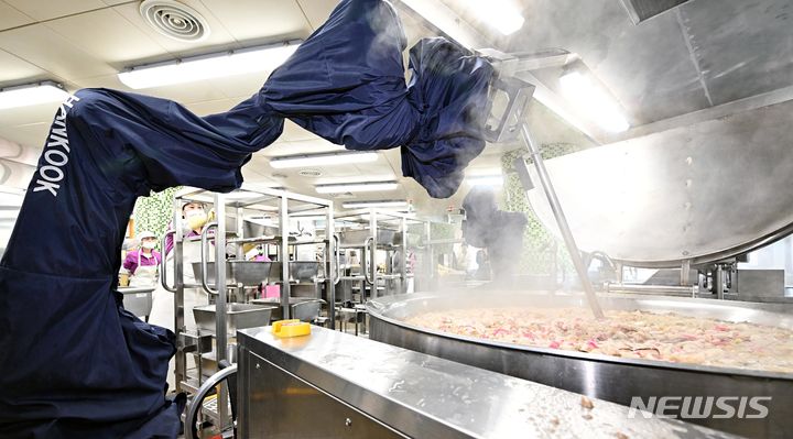 [서울=뉴시스] 김선웅 기자 = 서울시교육청이 급식종사자 결원 문제를 해결하기 위해 내놓은 조리로봇 지원책에 대해 급식종사자들이 '전시행정'이라고 비판했다. 사진은 서울 성북구 송곡중학교에서 급식로봇이 점심식사 조리 중인 모습. (공동취재) 2023.11.22. photo@newsis.com