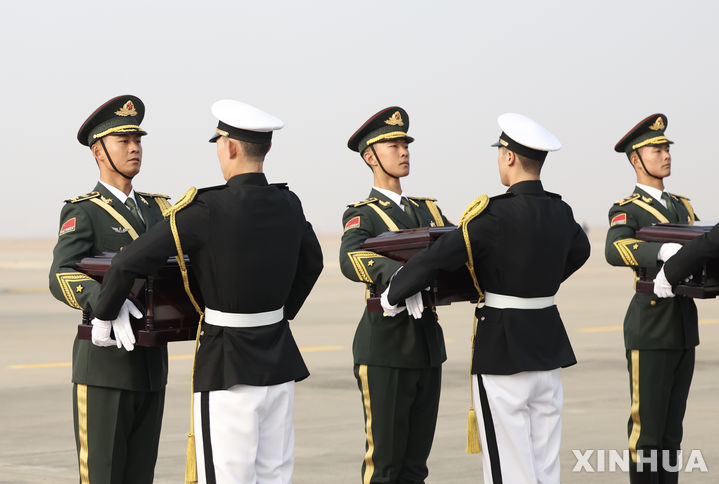[인천=신화/뉴시스] 23일 인천국제공항에서 제10차 중국군 유해 인도식이 열려 한국 군인들이 중국 의장대에게 중국군의 유해가 담긴 함을 인도하고 있다. 국방부는 6·25전쟁 중 한국 땅에서 전사한 중국군 유해 25구와 유품 335점을 중국 측에 인도했다. 한국은 2014년부터 중국군 유해를 인도해 지금까지 938구의 유해를 인도한 것으로 집계됐다. 2023.11.23.