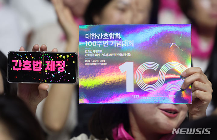 [서울=뉴시스] 지난 2023년 11월 23일 오후 서울 중구 장충체육관에서 열린 대한간호협회 100주년 기념대회에서 간호사가 피켓과 간호법 제정 문구를 들고 있는 모습. 2023.11.23. photo@newsis.com