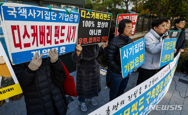[서울=뉴시스] 정병혁 기자 = 기업은행 디스커버리 사기피해대책위원회 관계자들이 24일 서울 양천구 남부지방법원에서 열린 장하원 등 피의자 구속 촉구 피해자 기자회견에서 피켓을 들고 있다. 2023.11.24. jhope@newsis.com